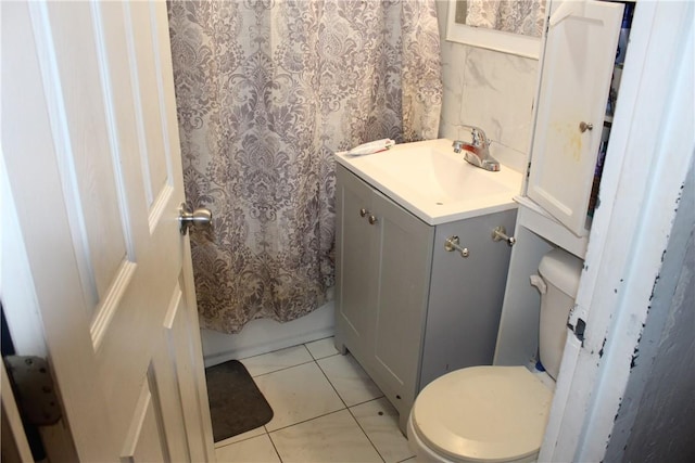 bathroom featuring tile patterned flooring, vanity, toilet, and walk in shower