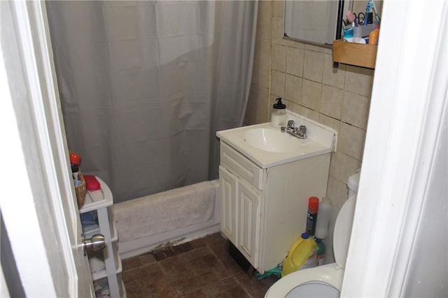 full bathroom with vanity, tile patterned floors, shower / bath combination with curtain, toilet, and tile walls