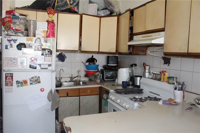 kitchen featuring backsplash, white appliances, and sink