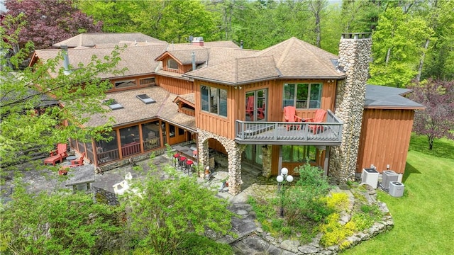 back of house featuring a patio area, a sunroom, and a yard