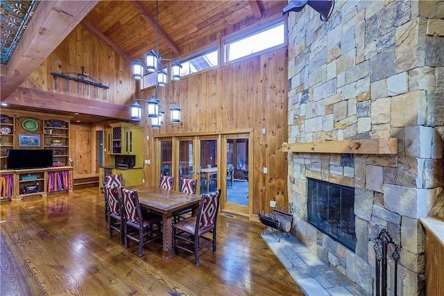 dining space featuring hardwood / wood-style floors, a fireplace, high vaulted ceiling, and wood ceiling