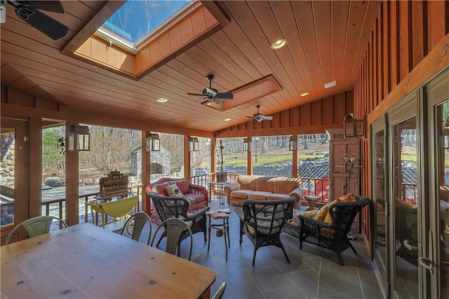 sunroom / solarium with a wealth of natural light, ceiling fan, wood ceiling, and lofted ceiling with skylight