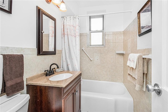 full bathroom featuring shower / bath combination with curtain, vanity, toilet, and tile walls