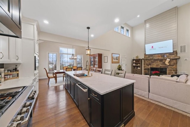 kitchen with dark hardwood / wood-style flooring, sink, decorative light fixtures, white cabinets, and a kitchen island