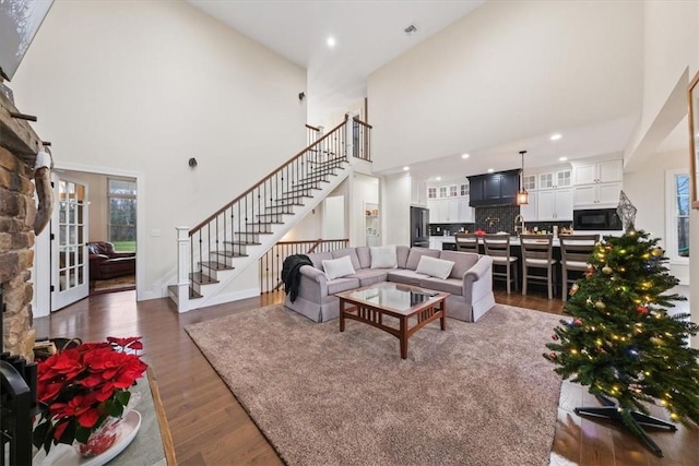 living room featuring french doors, a towering ceiling, and dark hardwood / wood-style floors