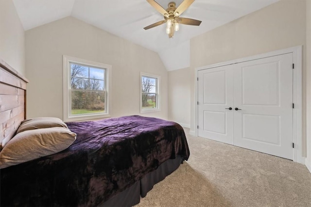 carpeted bedroom with ceiling fan, lofted ceiling, and a closet