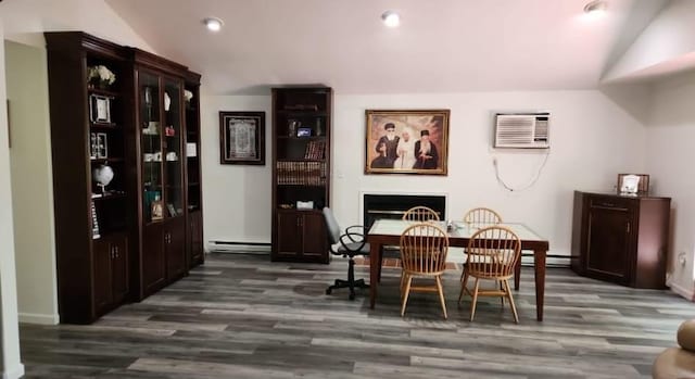 84 Upper Vacation Blvd, Fallsburg, NY 12733 - dining space featuring baseboard heating, vaulted ceiling, a fireplace, dark wood-type flooring, and a wall unit AC