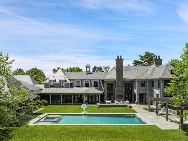 rear view of house with a pergola, a lawn, a patio, and a pool with hot tub