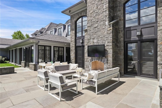 view of patio with an outdoor living space with a fireplace