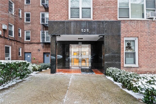 snow covered property entrance with french doors