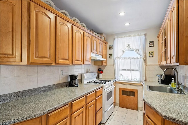 kitchen featuring light tile patterned flooring, tasteful backsplash, white gas stove, and sink