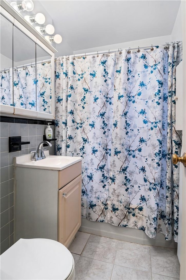 full bathroom featuring tile patterned flooring, vanity, toilet, and tile walls