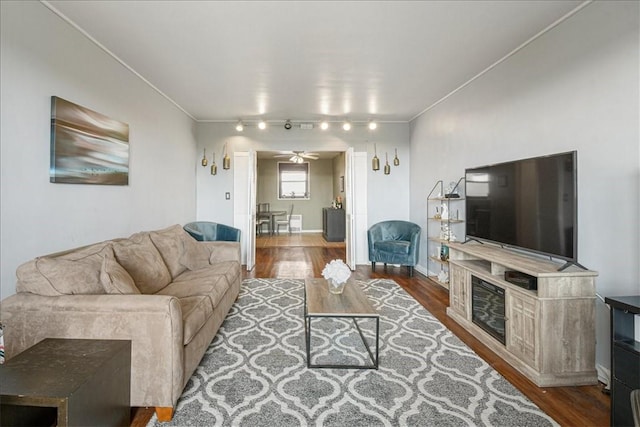 living room with ceiling fan, crown molding, and dark hardwood / wood-style floors