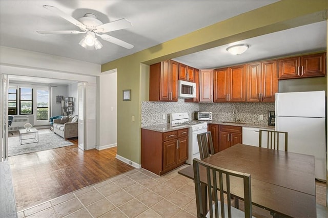 kitchen featuring decorative backsplash, white appliances, light hardwood / wood-style floors, and ceiling fan