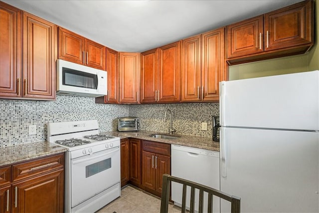 kitchen with sink, light stone counters, white appliances, decorative backsplash, and light tile patterned floors