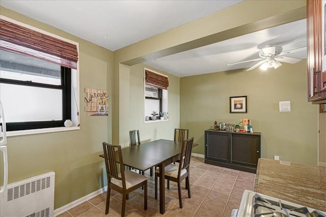 tiled dining space featuring radiator and ceiling fan