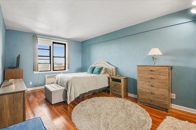 bedroom with dark hardwood / wood-style flooring and radiator