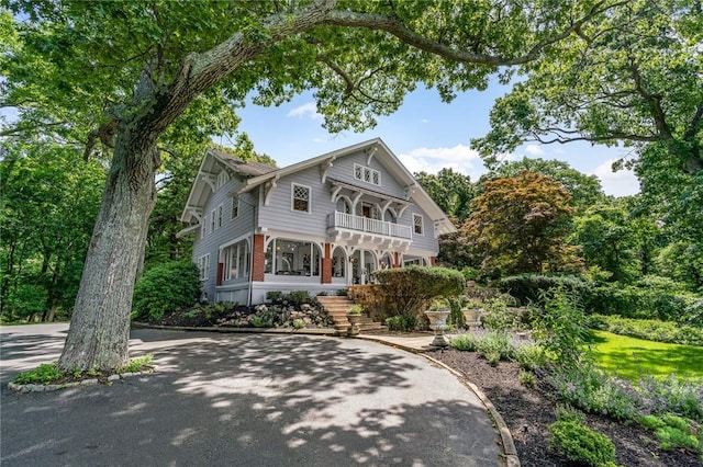 victorian-style house featuring a porch and a balcony