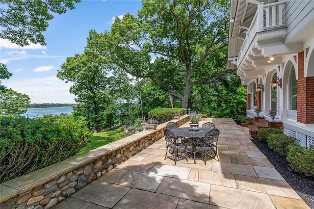 view of patio featuring a balcony and a water view