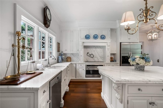 kitchen featuring white cabinets, stainless steel appliances, hanging light fixtures, and a healthy amount of sunlight