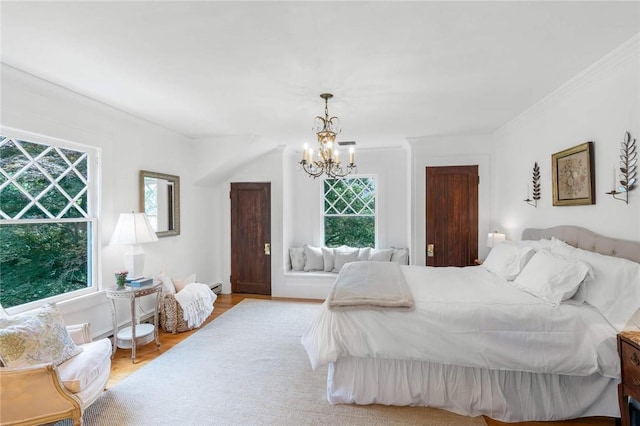 bedroom featuring a notable chandelier, light wood-type flooring, ornamental molding, and baseboard heating