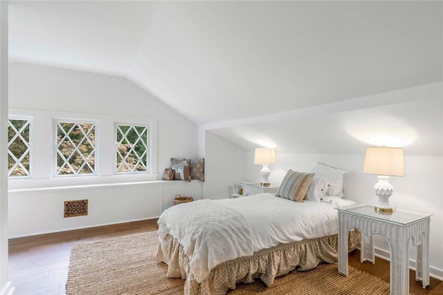 bedroom with vaulted ceiling and hardwood / wood-style flooring