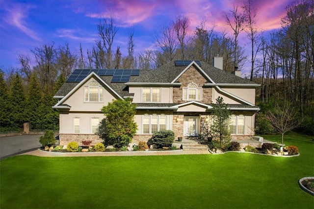 view of front of house with a yard and solar panels