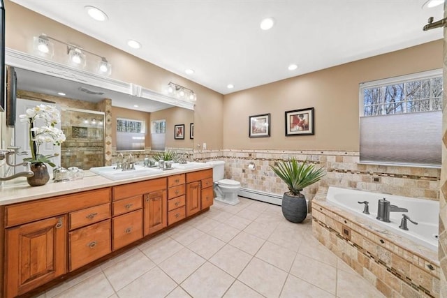 full bathroom with tile patterned flooring, plenty of natural light, vanity, and a baseboard radiator