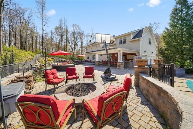 view of patio with an outdoor living space with a fire pit