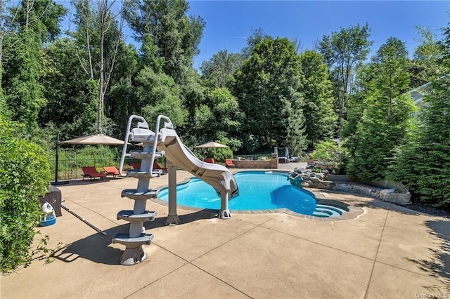 view of swimming pool featuring a patio area and a water slide