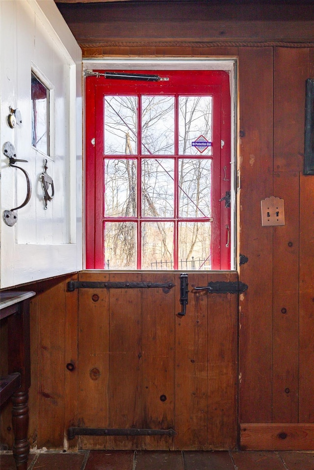 doorway to outside featuring wooden walls