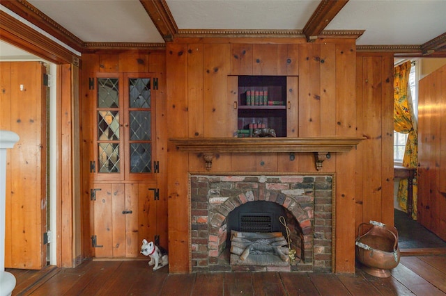 unfurnished living room with beamed ceiling, dark hardwood / wood-style floors, wood walls, and ornamental molding