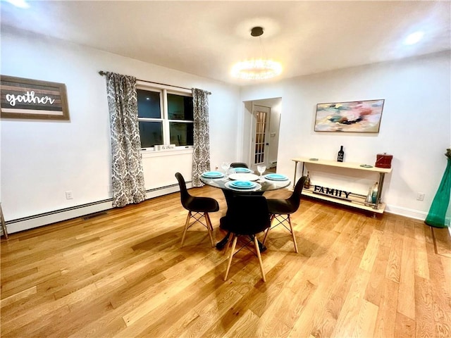 dining area with a chandelier, light hardwood / wood-style flooring, and a baseboard radiator