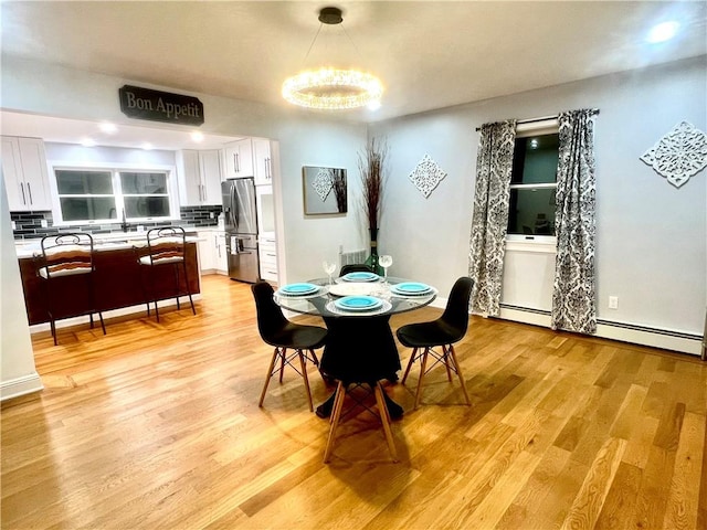 dining area featuring light hardwood / wood-style flooring, a chandelier, and sink