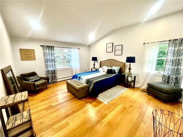 bedroom featuring wood-type flooring, lofted ceiling, and a baseboard heating unit