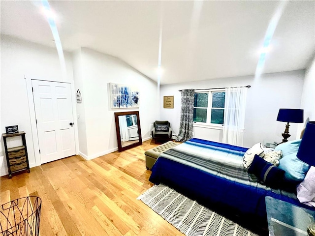 bedroom featuring wood-type flooring and vaulted ceiling