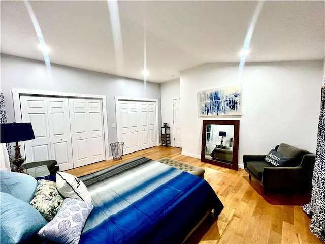 bedroom with multiple closets and hardwood / wood-style flooring