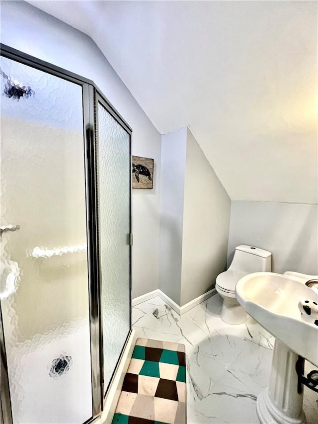 bathroom featuring toilet, a shower with door, and vaulted ceiling