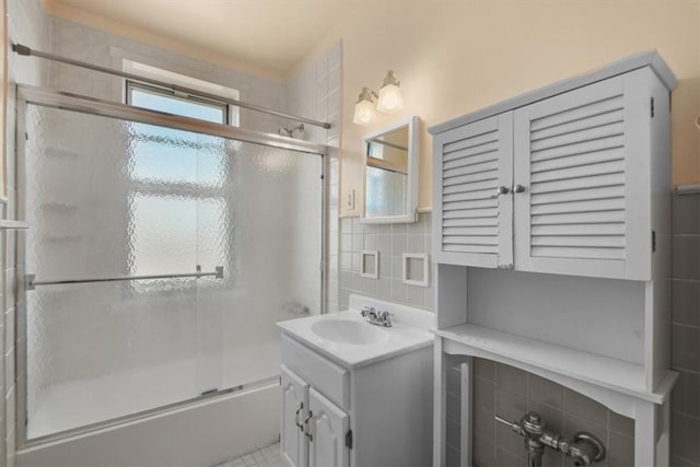 bathroom with tile patterned floors, vanity, enclosed tub / shower combo, and backsplash