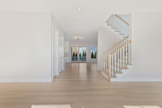 entrance foyer featuring light wood finished floors, stairway, and baseboards