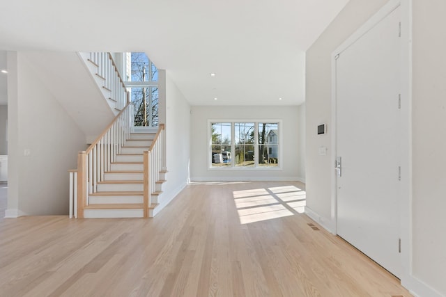 foyer entrance featuring stairs, recessed lighting, baseboards, and light wood-type flooring