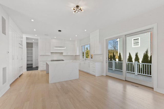 kitchen featuring white cabinetry, light wood-type flooring, and a kitchen island