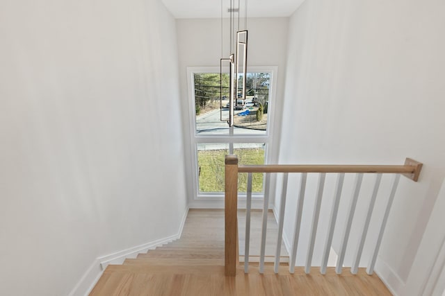 stairway featuring baseboards and wood finished floors