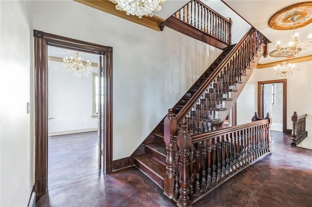 stairs with concrete floors, ornamental molding, and a chandelier