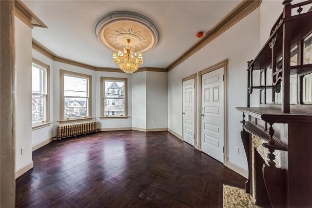 interior space with a notable chandelier, ornamental molding, radiator, and dark parquet floors