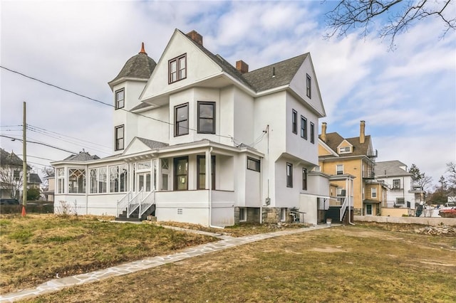 101 Summit Ave, Mount Vernon, NY 10550 - view of property exterior featuring a sunroom, stucco siding, a chimney, and a lawn