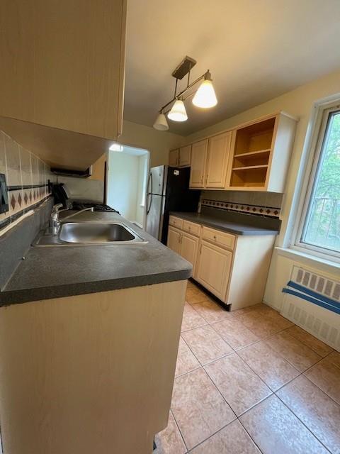 30 S Cole Ave Unit 3E, Spring Valley, NY 10977 - kitchen featuring dark countertops, a sink, freestanding refrigerator, light tile patterned floors, and tasteful backsplash