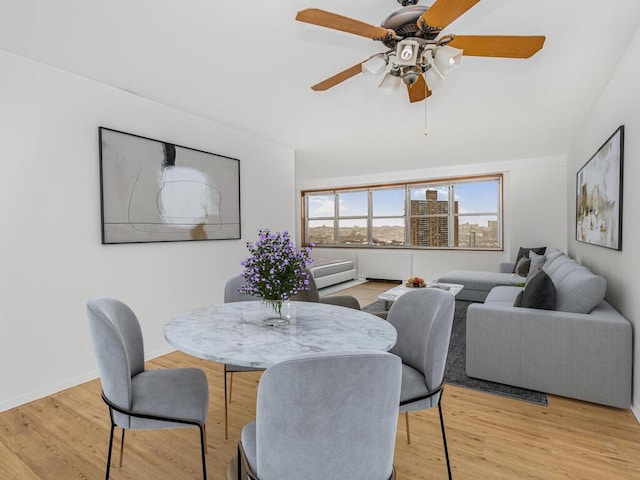 dining area with light hardwood / wood-style flooring and ceiling fan