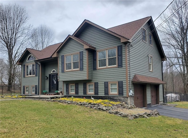 raised ranch featuring a garage and a front yard