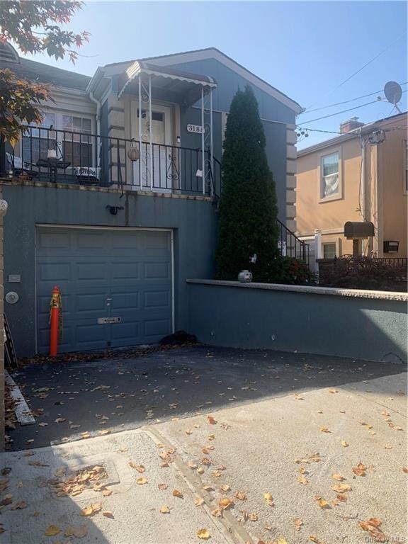 view of side of property featuring a garage and a balcony